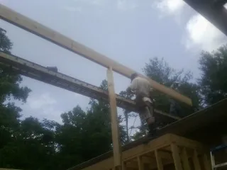 Carpenter setting a ridge beam over a new addition frame — Ice Dam Removal by Roofing Brothers in Waldwick