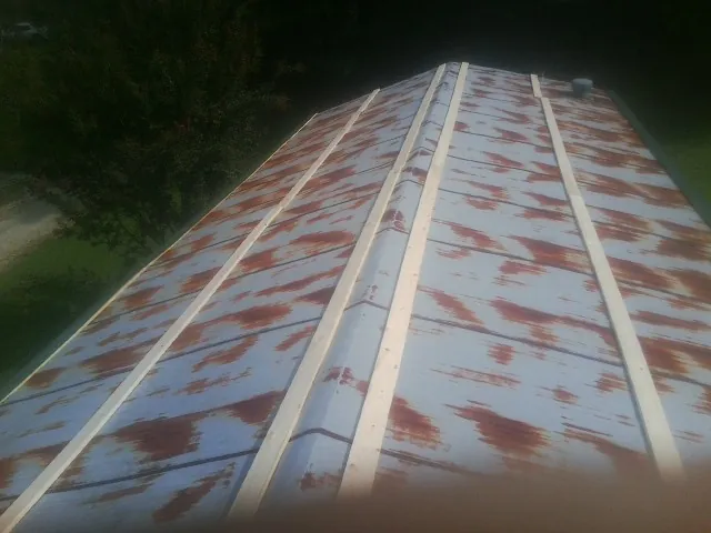 Rusted metal roof panels with new wood purlins before replacement — Storm Damage Roof Repair in Waldwick by Roofing Brothers