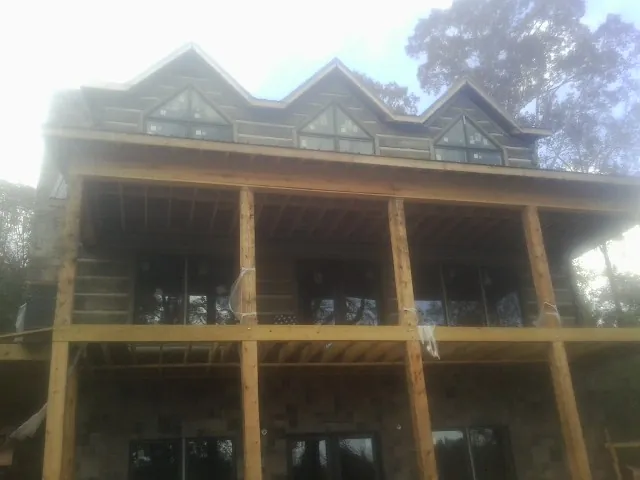 Dormers and porch framing on a large log home under construction — Roof Coating work by our crew in Waldwick